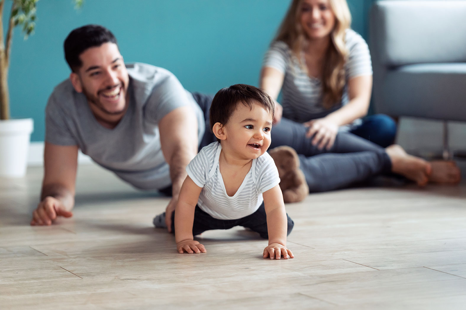 Parents watch their child crawling, demonstrating healthy child development