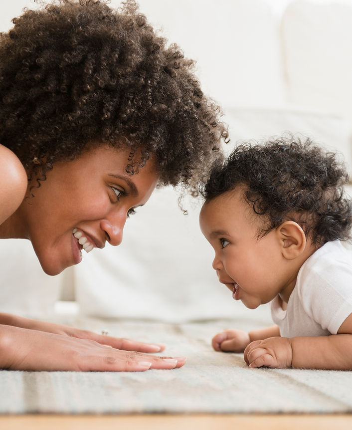 "Mom with baby on floor playing"
