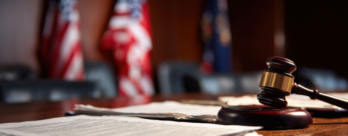 "Courtroom gavel and legal documents on a judge's bench."